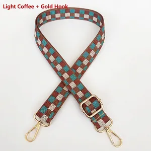 Dettaglio tracolla in tela a scacchi caffè chiaro e blu con ganci in metallo oro