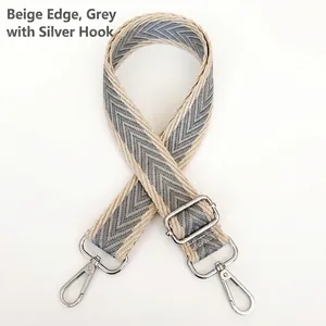 Detail of adjustable gray herringbone canvas strap with silver metal hooks and buckle