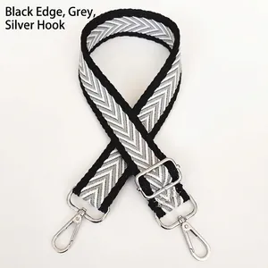 Detail of adjustable black and grey chevron canvas bag strap with silver metal lobster clasps