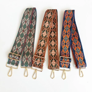 Detail of three adjustable wide woven bag straps with vintage patterns and gold lobster clasps