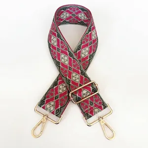 Close-up of woven bag strap with geometric patterns and golden adjustable metal hooks