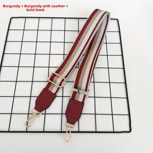 Détail de la bandoulière réglable à rayures bordeaux en cuir PU et mousquetons dorés