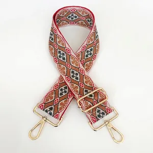 Detail of ethnic geometric embroidered bag strap with gold lobster claw clasps