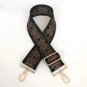 Detailed close-up of retro woven shoulder strap with green geometric patterns and gold clips