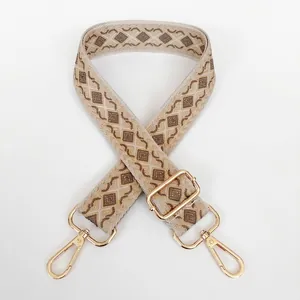 Detail view of woven diamond pattern bag strap in beige and dark khaki with gold hooks