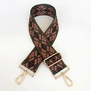 Detail of adjustable canvas bag strap with colorful woven diamond pattern and gold metal hook