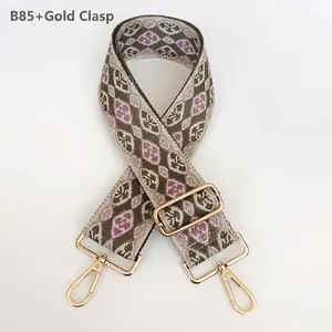 Close-up of geometric pattern on wide woven bag strap with golden lobster clasps