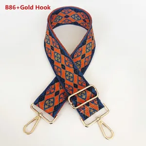 Close-up of geometric jacquard bag strap with gold hooks and adjustable metal slider