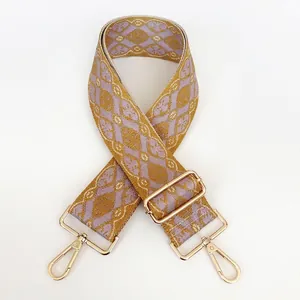 Macro detail of wide woven strap with mustard diamond pattern and gold lobster clasp