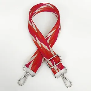 Adjustable wide woven shoulder strap with red geometric pattern and silver hooks