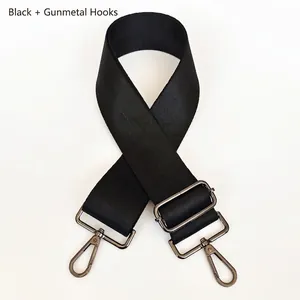 Détail de la bandoulière en nylon noir avec crochets réglables en métal gris fusil