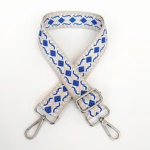 Macro detail of beige canvas bag strap with blue diamond jacquard and silver hardware