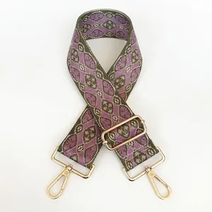 Detail of purple and olive green jacquard embroidered wide bag strap with gold hooks