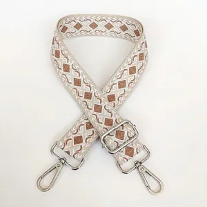 Close-up of beige canvas bag strap with khaki diamond jacquard and silver metal hooks