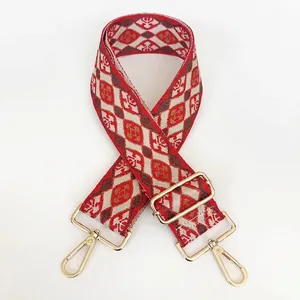Detail of red and grey geometric jacquard wide canvas strap with gold metal hooks