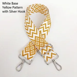 Close-up of yellow and white geometric nylon bag strap with silver metal hooks