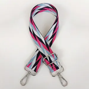 Detail of adjustable woven shoulder strap with pink geometric arrow pattern and silver hooks