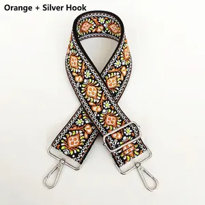Close-up of bohemian style embroidered bag strap with orange patterns and silver hooks