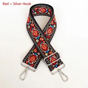 Close-up of ethnic style embroidered bag strap with red patterns and silver metal hooks
