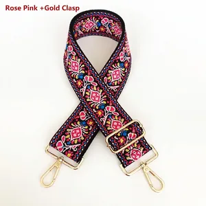 Detailed view of rose pink ethnic embroidery bag strap with golden rotating hooks