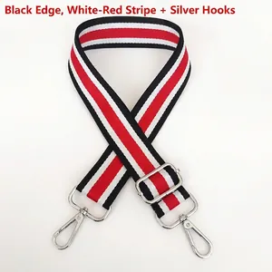 Detail of red, white and black striped canvas bag strap with silver metal hooks