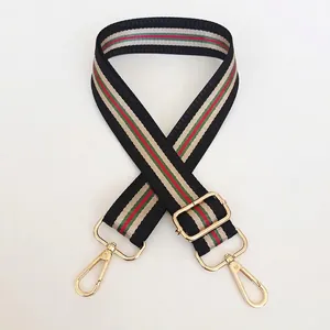 Detail of adjustable vintage black woven bag strap with green-red stripes and gold hardware