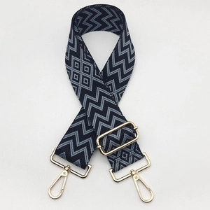 Close-up of durable nylon woven bag strap with geometric patterns and gold metal hooks