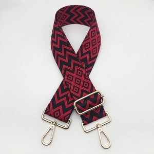 Close-up of adjustable red and black geometric pattern strap with gold metal hooks