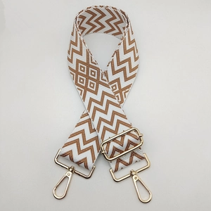 Detail view of woven geometric bag strap with premium gold metal lobster clasps