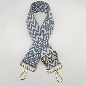 Close-up of durable grey and white woven nylon strap with gold metal lobster clasps