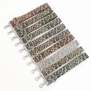 Detail view of colorful leopard print bag straps with adjustable silver metal buckles
