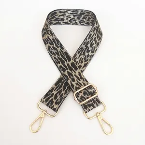 Detail of adjustable leopard print bag strap with gold metal buckles and grey pattern