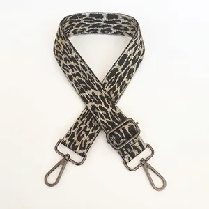 Detailed view of grey leopard print bag strap with gunmetal swivel snap hooks and slider