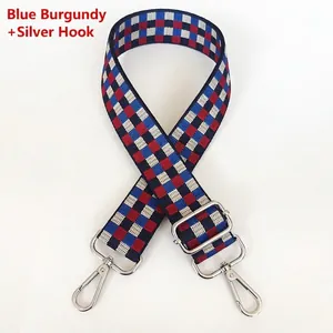 Détail de la bandoulière réglable à damier bleu et bordeaux avec mousquetons argentés