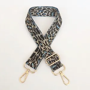 Close-up of adjustable leopard print bag strap in light blue with gold metal hooks