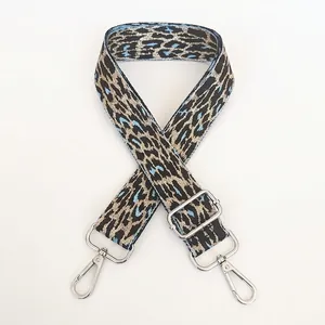 Detail of light blue leopard woven bag strap with silver metal swivel hooks and buckle
