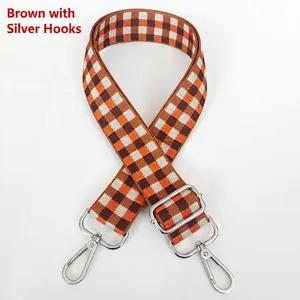 Détail de la bandoulière tissée à damier marron et orange avec crochets argentés