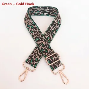 Detail of adjustable green leopard print bag strap with polished gold metal swivel hooks