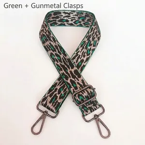 Detail view of adjustable green leopard print bag strap with gunmetal swivel hooks