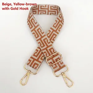 Close-up of cream and tan jacquard bag strap with adjustable golden metal hooks