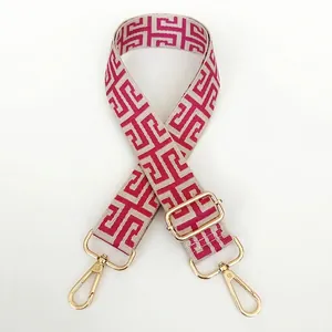 Close-up of ethnic style beige and magenta canvas bag strap with golden metal hardware