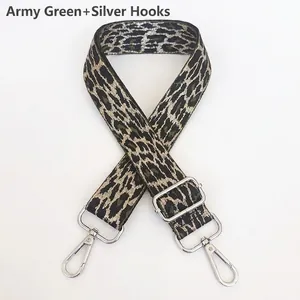 Detail of army green leopard pattern wide bag strap with polished silver metal hooks