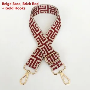 Detail of adjustable beige and red geometric woven bag strap with gold metal hooks