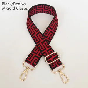 Detail showing the red and black meander pattern woven bag strap with gold lobster clasps