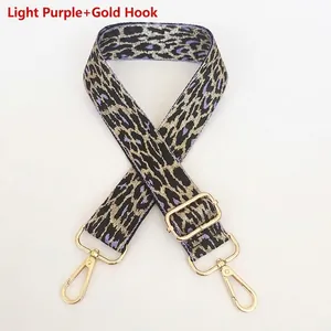 Detail view of woven leopard bag strap in light purple with gold metal hooks and buckles