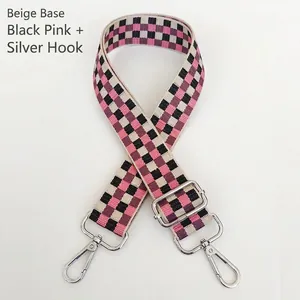 Détail d'une bandoulière tissée réglable avec motif en damier rose et noir