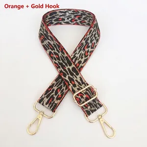 Detail of adjustable leopard print bag strap in orange and gold with metal swivel hooks