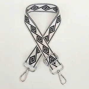 Close-up of off-white wide nylon strap with black geometric pattern and silver hook