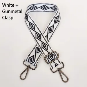 Detail of adjustable wide nylon bag strap with black geometric pattern and gunmetal hooks