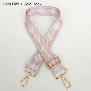 Light pink wide nylon bag strap with white geometric pattern and gold metal hooks